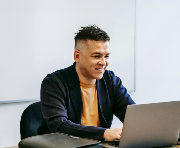 Lachende man aan het werk op een laptop